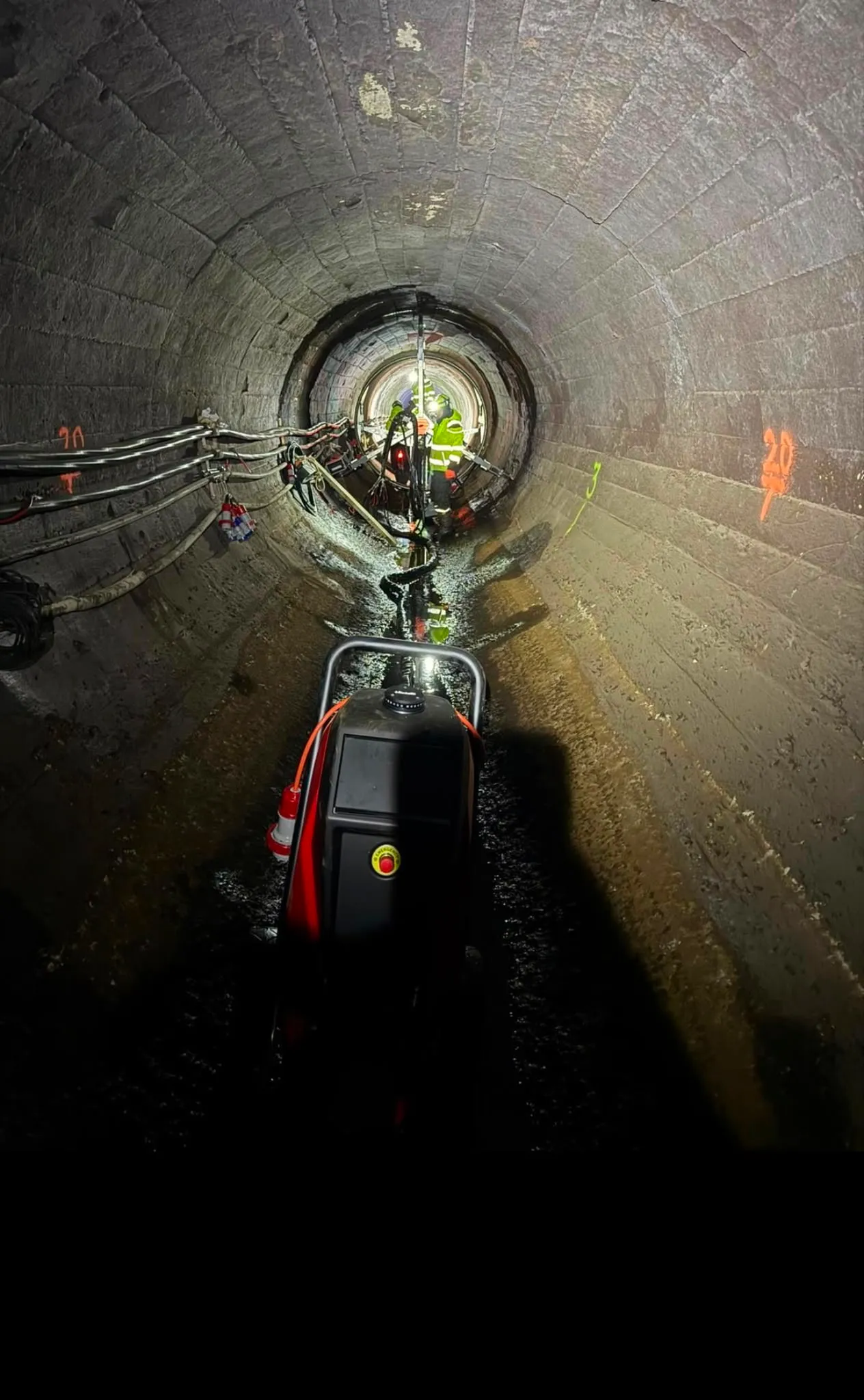 Tunnel indefra med udstyr på bunden og arbejdslys længere inde.