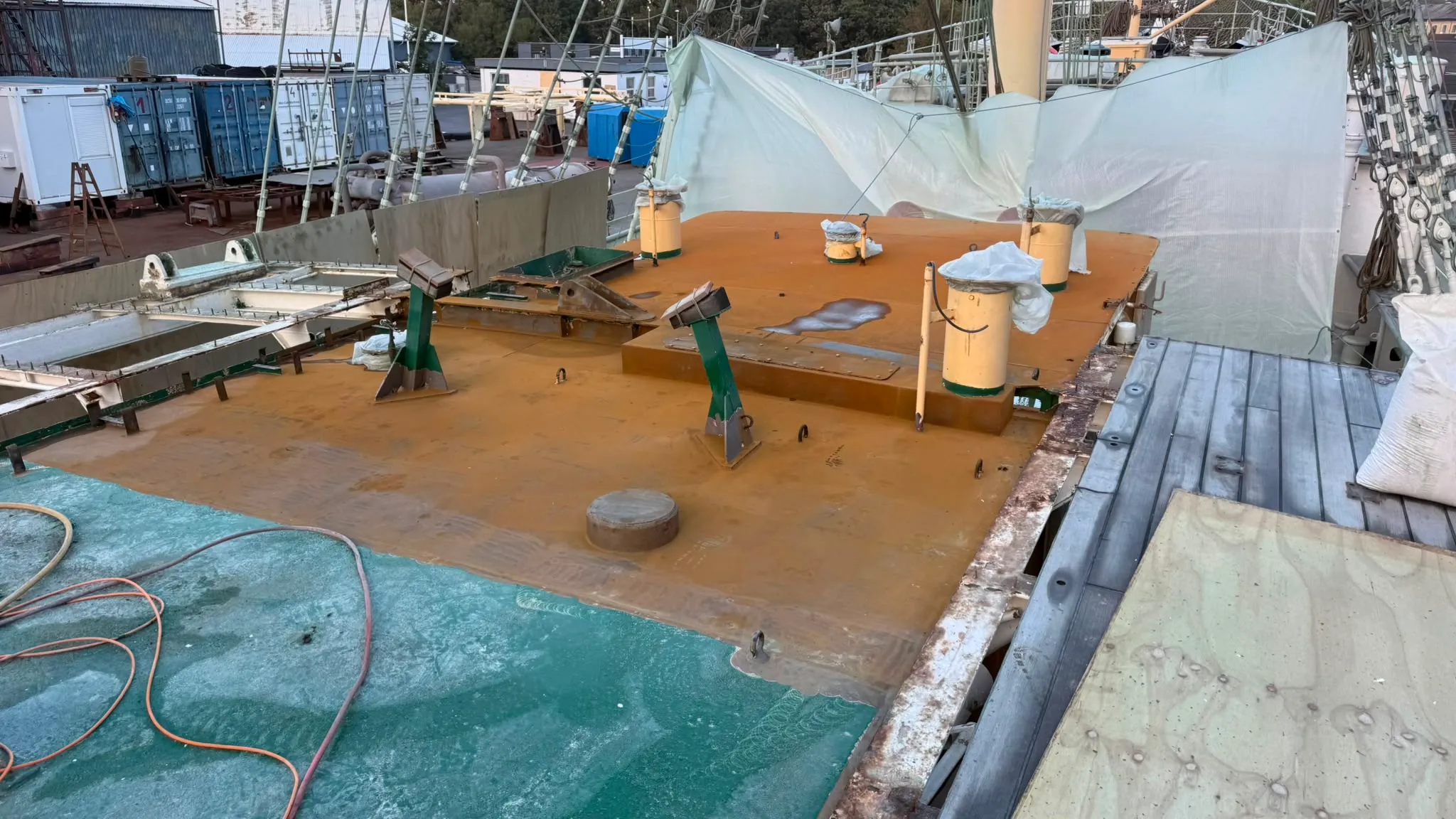 Skibsdæk med flere lag coating i orange og grøn.