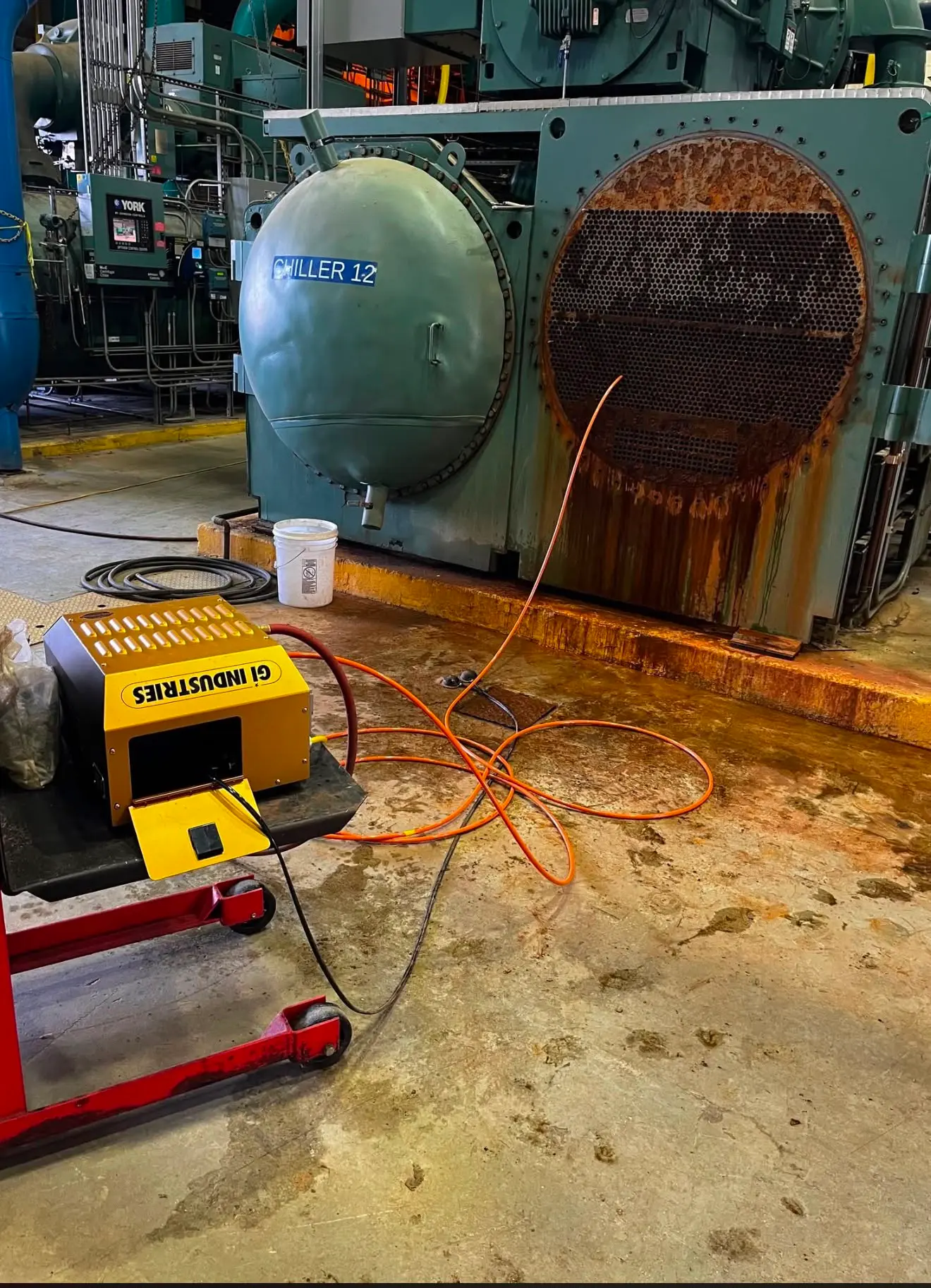 Industriel varmeveksler og chiller med åbnet endebund og rørplan klar til UHP-rensning.